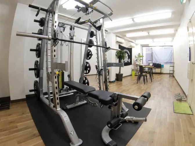 スミスマシンとベンチが並ぶOWLIVE FITNESSのトレーニングルーム内観